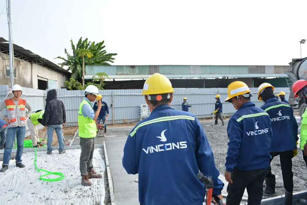 L'équipe en casques de chantier réunie devant un chantier