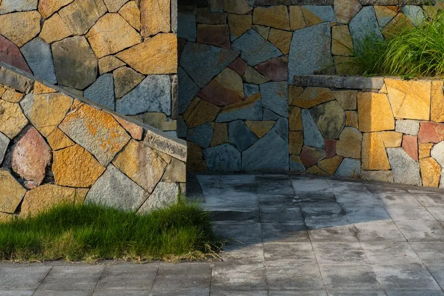 Mur de soutènement en pierres naturelles bordant une terrasse pavée